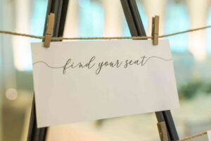 White "find your seat" wedding reception sign hung with clothes pinswedding seating chart